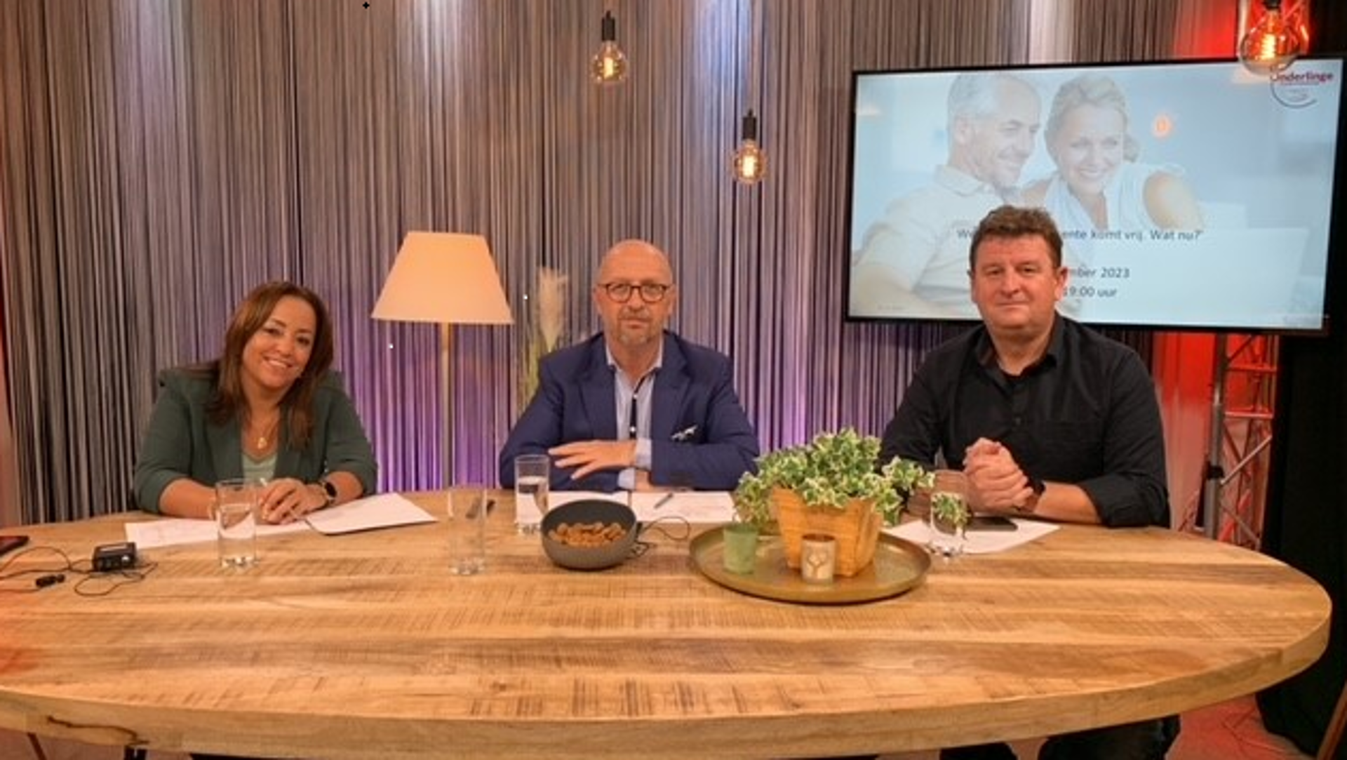 Drie mensen aan tafel bij de webinar